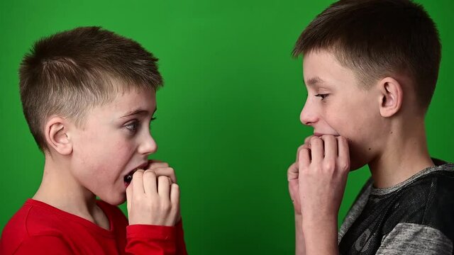 Guys on a green background, boys smiling, children wear dental plaques, crooked teeth in children.