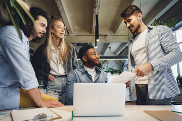 Smiling multiracial coworkers working together at office meeting, have a discussion