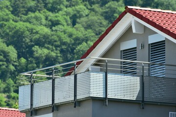 Begrünter Balkon mit Edelstahl-Sichtschutz und Edelstahl-Geländer an einer Neubau-Hausfront