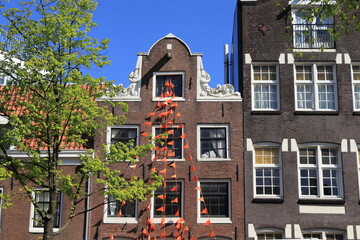Amsterdam Jordaan Traditional House Facade with Orange Bunting and Green Tree
