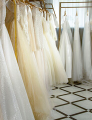Different wedding dresses on hangers in boutique