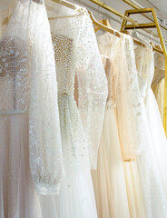 Different wedding dresses on hangers in boutique