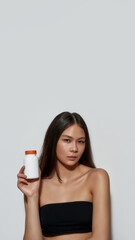 Portrait of young asian girl holding pills can