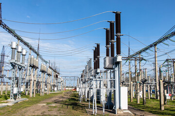 Part of a high voltage substation with high voltage circuit breakers and transformers.