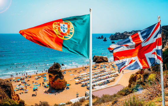 Portugal and United Kingdom flags with Algarve, Portugal beach in background - travel during Covid concept as UK removes Portugal from Green destination