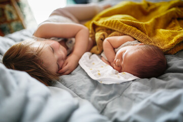 cute baby siblings sleep together, newborn baby and toddler older sister, sibling relationship in the family when the youngest was born