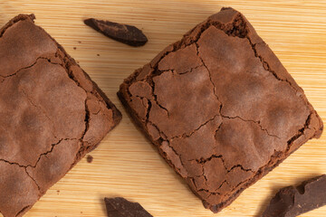 Pieces of delicious brownies on wooden table.