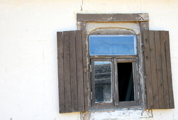 shuttered window of an old rural clay house