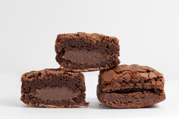 A pile of brownies stuffed with chocolate on white background.