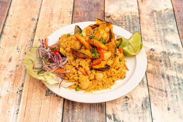 Delicious Peruvian dish of seafood rice. Prawns, scallops, mussels, clams, squid, red onion, and lime