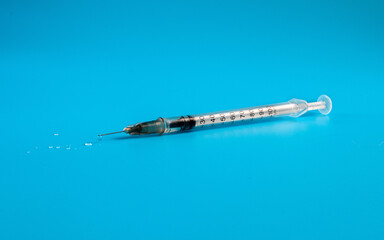 Medical insulin syringe with drops of medicine.