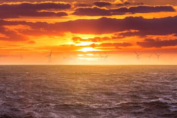 Renewable green electricity wind power generation offshore. Sunrise at decarbonization industry windmills business for regenerative energies. Clean energy renewables preventing climate change