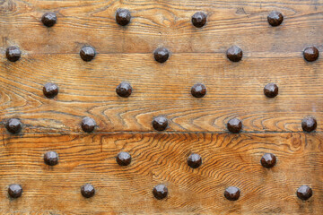 Iron rivets on a wood front door fragment