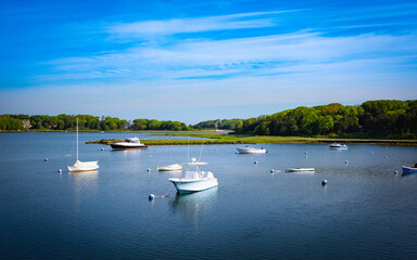Fototapeta na wymiar Moored boats in tranquil harbor in Falmouth on Cape Cod. Idle island seascape in the summer in New England.