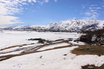 wooden house on a background of snowy mountains - Hardangervidda