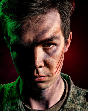 A close-up portrait of a soldier in scars and battle paint, illuminated by green light against a backdrop of red smoke