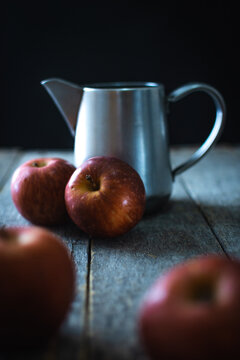 Still life of red apples and a metal kettle