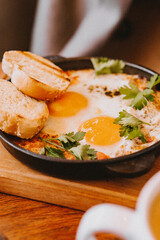 Breakfast with eggs and tomato,  in a frying pan