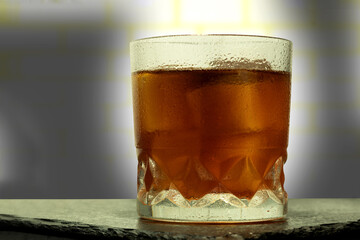 A glass with an alcoholic drink and ice