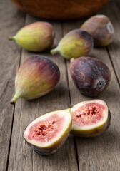 Figs with cut fruit over wooden table. Short depth of field