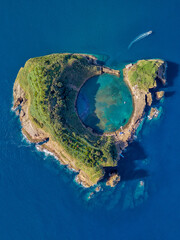Fototapeta premium Azores aerial panoramic view. Top view of Islet of Vila Franca do Campo. Crater of an old underwater volcano. San Miguel island, Azores, Portugal. Heart carved by nature. Bird eye view.