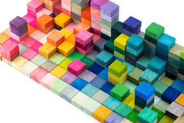 Spectrum of stacked multi-colored wooden blocks with white space in front. Background or cover for...