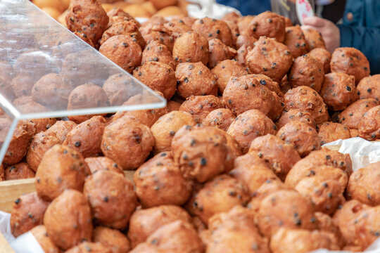 Selective focus of Oliebol in showcase display at the market, Typical food or sweet commonly known as Dutch doughnuts or dutchies, Oliebollen are traditionally eaten on New Year's Eve, Netherlands.
