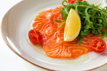 Salmon carpaccio served with lemon and arugula