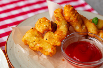 Deep fried chicken nuggets with sauce served on table