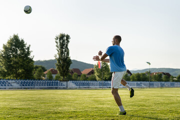 Full length soccer football player kicking the ball on game or training header