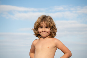 Fototapeta na wymiar Portrait of happy shirtless kid smiling summer outdoors sky background, boy