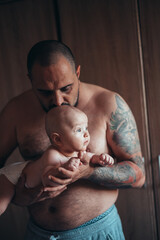 Tattooed bearded father playing with his son