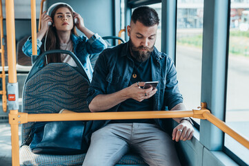 Young beautiful passengers using smartphones while riding the bus