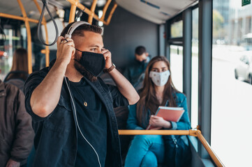 Young man wearing protective mask while riding a bus