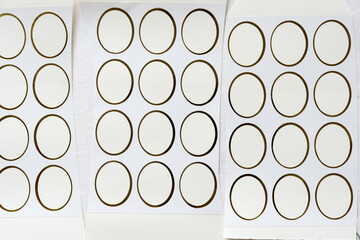 gold tipped ovals - highlighting their negative space - fixed to textured paper - variously arranged on old paper - photographed from above in a flat lay style - with ambient light