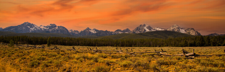 Fototapeta na wymiar a split rail fence, pasture and meadow, and the Sawtooth Mountains near Stanley, Idaho.