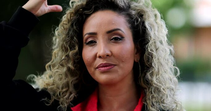 Confident latin hispanic woman portrait adjusting hair and jacket