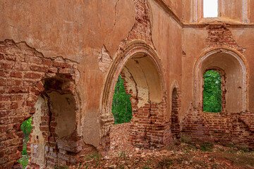 Fototapeta na wymiar The arch in the abandoned old red brick church. Inside view. Russia, Smolensk region, 1753.