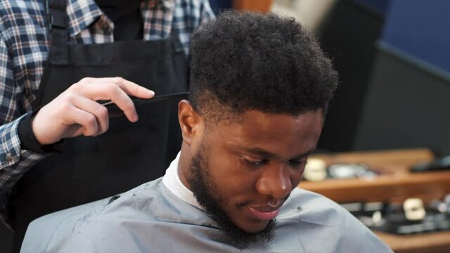 Young African-american man visiting barbershop for haircut