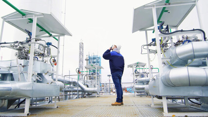 Engineer talking on walkie-talkie outside gas provessing manufacturing