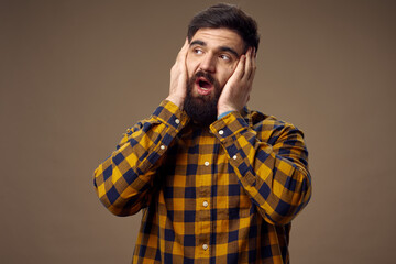 bearded man in plaid shirt holding on to face emotions