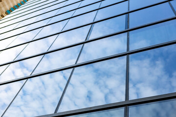 Obraz na płótnie Canvas Glass skyscraper against blue sky, view from bottom