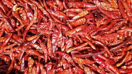 A large number of dried red peppers are used as a background..Dried red peppers at a local market