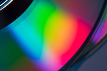 Abstract photo of the reflection of the bottom of a CD displaying a wide array of colors on its...