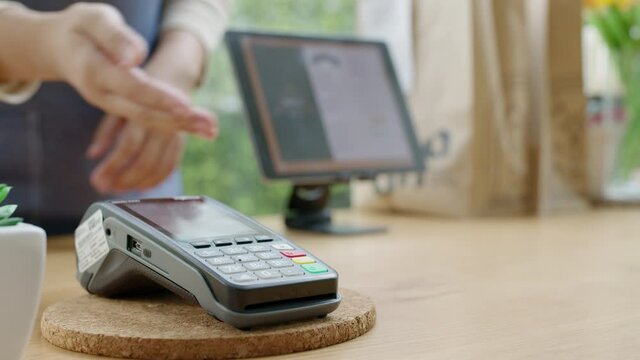 Close-up hand asia woman people work in small sme coffee cafe shop store owner use cashless wifi qr code nfc scan app smart pos reader sale in take out food drink order in urban city life contactless.