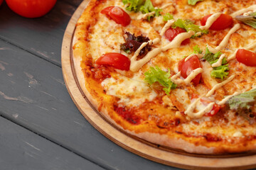 Close up of freshly baked pizza on black wooden table