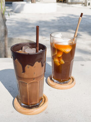 A glass of iced mocha and iced americano with coconut juice