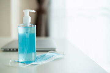 Hygiene protective face mask and laptop computer on the table in home office.