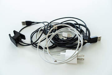 Vintage USB power cords rolled up on the white table from top angle close up.