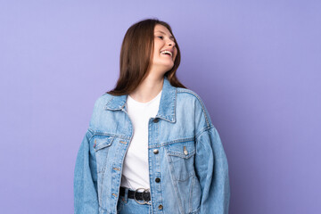 Teenager caucasian girl isolated on purple background laughing